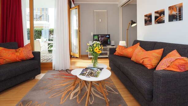A modern living room with two sofas, a coffee table, and a TV. - Apartment with 1 bedroom and terrace (Seebad Heringsdorf)