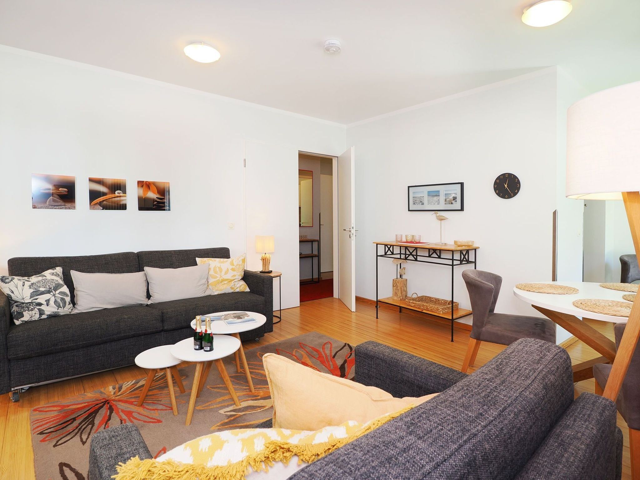 Una sala de estar moderna con un sofá, una mesa de centro y un comedor con mesa y sillas.