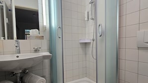 A bathroom with a sink, mirror, towel rack, shower, and a bathtub. - Appartement mit 2 Schlafzimmern und Balkon (Seebad Heringsdorf)