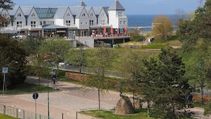 A coastal hotel with a modern architectural design, featuring a prominent tower and multiple levels with large windows. - Appartement mit 2 Schlafzimmern und Balkon (Seebad Heringsdorf)