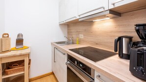 Ett modernt kök med en bänkskiva i trä, rostfria vitvaror och en inbyggd ugn.