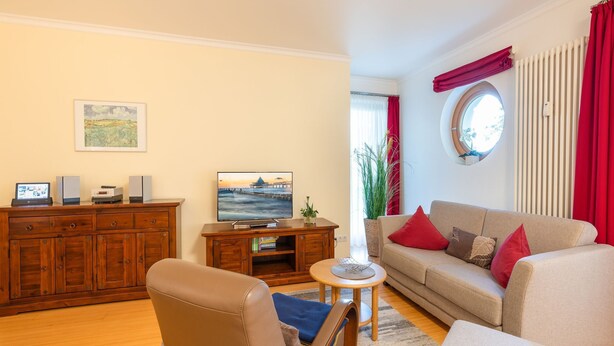 Ett vardagsrum med ett träskåp, en tv, en soffa och ett soffbord.