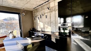Una cocina moderna con una isla grande, electrodomésticos de acero inoxidable y vistas al exterior.