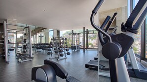 A modern gym with treadmills, weight machines, and free weights.