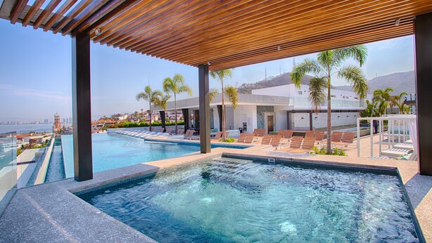 A pool area with a view of the city skyline, including a tall tower.