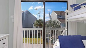 Un balcón con vista a casas y palmeras.