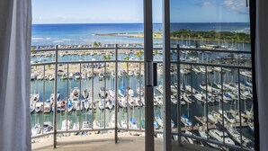 Ein Yachthafen mit zahlreichen vertäuten Booten, Blick von einem Balkon mit großen Fenstern.