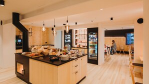 Una cuina moderna amb una illa central, armaris de fusta i un frigorífic integrat.