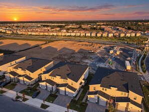 Zona residencial con varias casas de dos pisos, un estacionamiento y un sitio de construcción.
