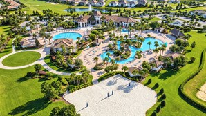 A golf course with a large swimming pool, multiple tennis courts, and a well-maintained lawn area.
