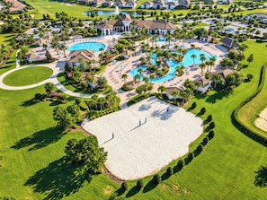 A golf course with a large swimming pool, multiple tennis courts, and a well-maintained lawn area.