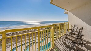 Un balcon avec vue sur la plage et une piscine.