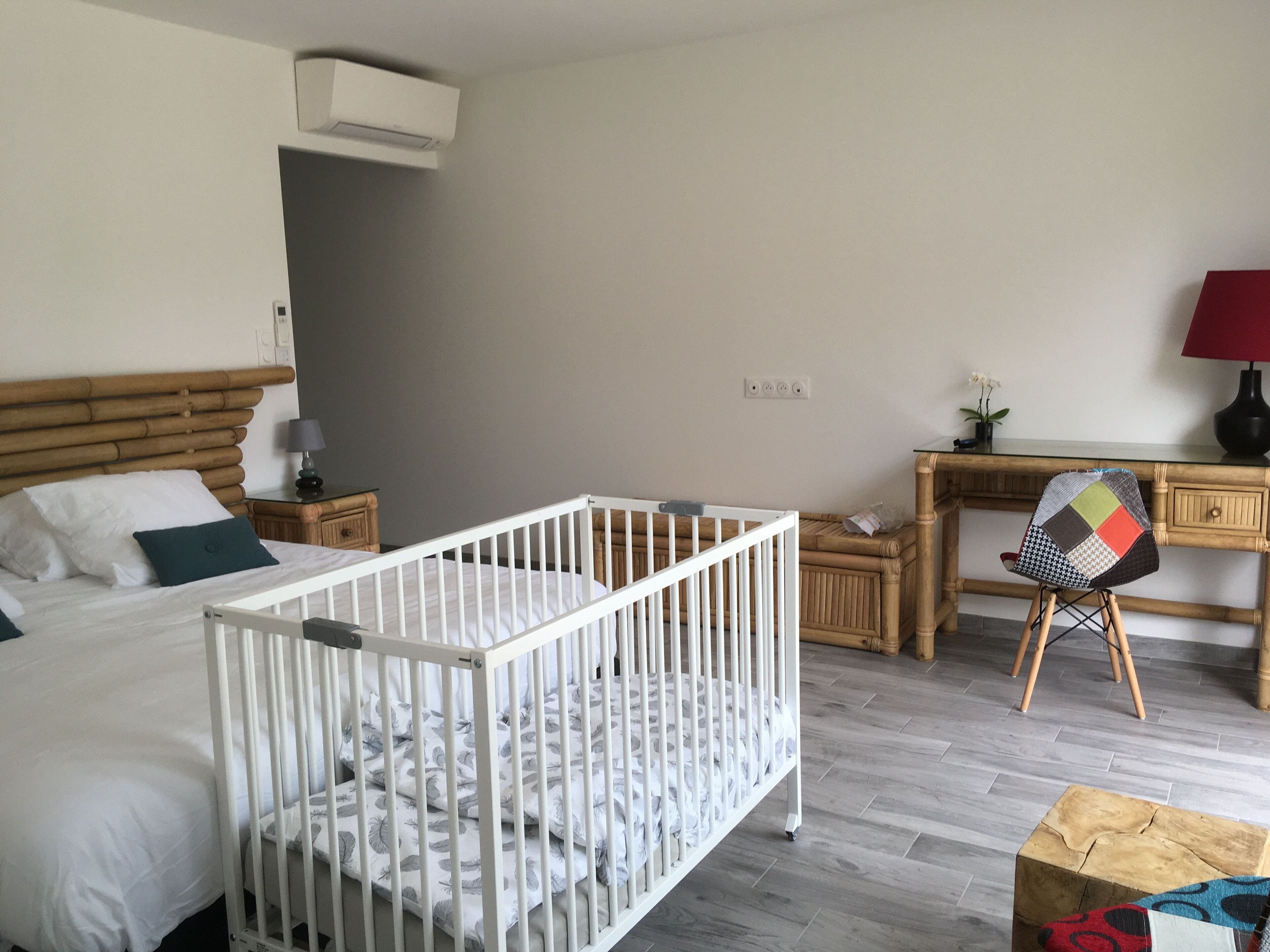 Una habitación infantil con una cuna, una cama, un escritorio y una silla.