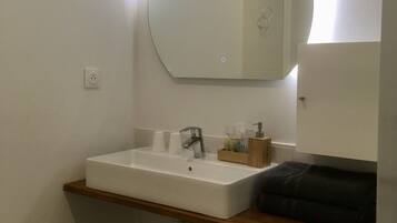 Ein Badezimmer mit Waschbecken, Spiegel und Handtuchhalter.