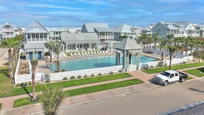 Ein Resort mit Schwimmbad, mehreren Gästehäusern und einem weißen Pickup-Truck in der Nähe.