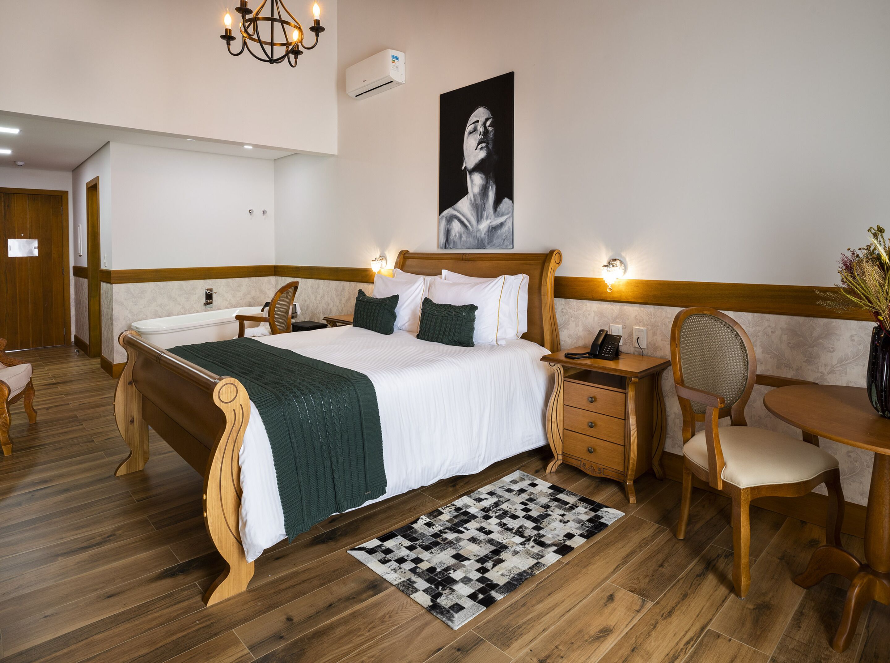 A hotel room with a large bed, wooden headboard, bedside tables, a desk, and a chair.