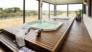 A spa area with two hot tubs, wooden deck, and a view of the countryside. - Cerro Azul Hotel Fazenda (Capao Alto)