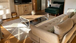 A living room with a sofa, a coffee table, a TV, and a cabinet. - Sumptuous Cap Ferret Style House (La Teste-de-Buch)