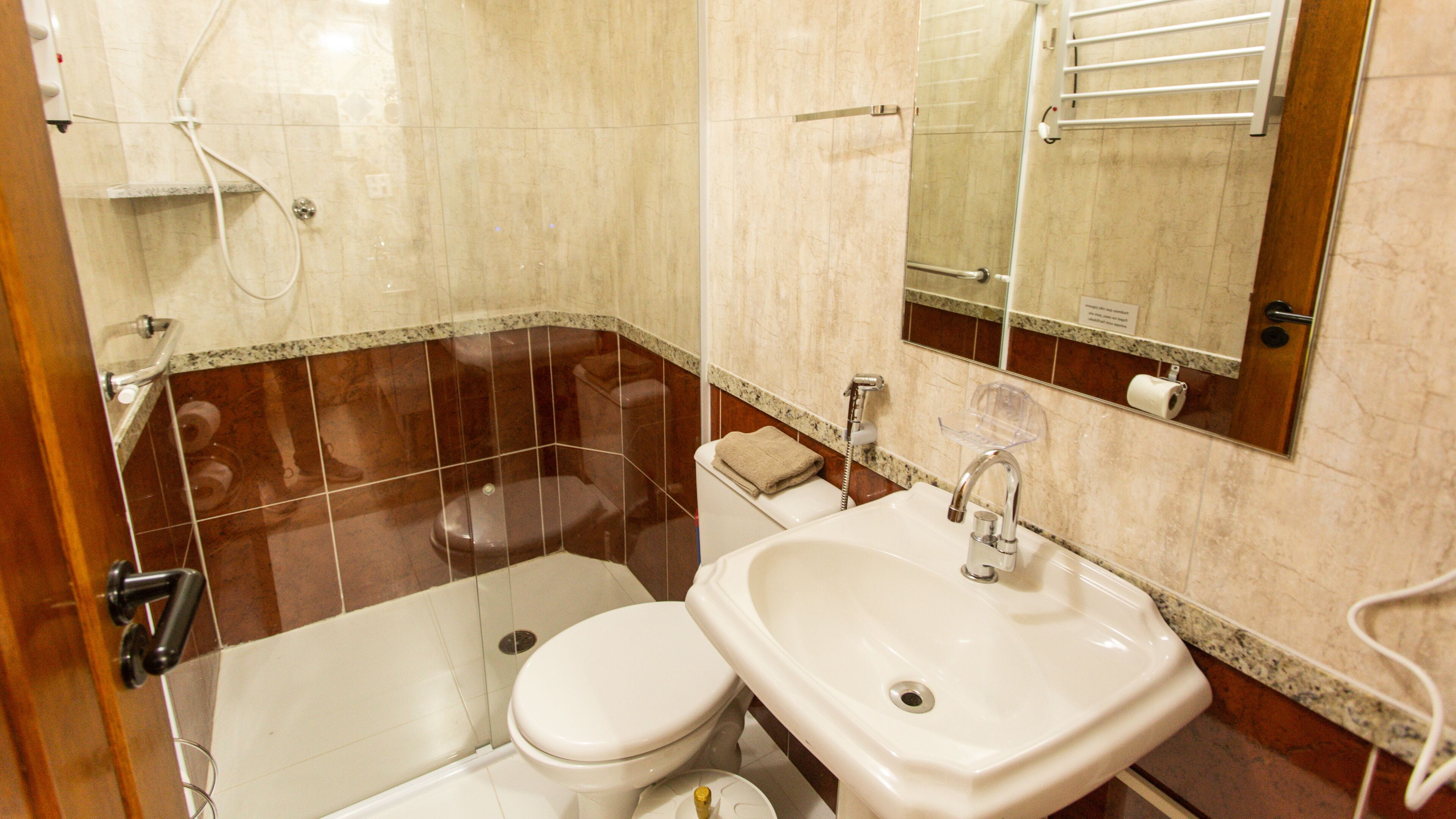 A bathroom with a toilet, sink, and shower.