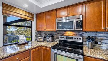 Una cocina moderna con armarios de madera, electrodomésticos de acero inoxidable y encimera de granito.