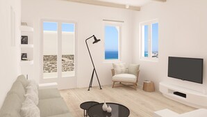 Un salon moderne comprenant un canapé, une table basse, un fauteuil, une lampe sur pied et un téléviseur.