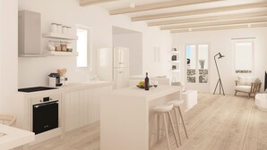 Une cuisine moderne avec des meubles blancs, un four encastré et un îlot central doté de tabourets de bar.