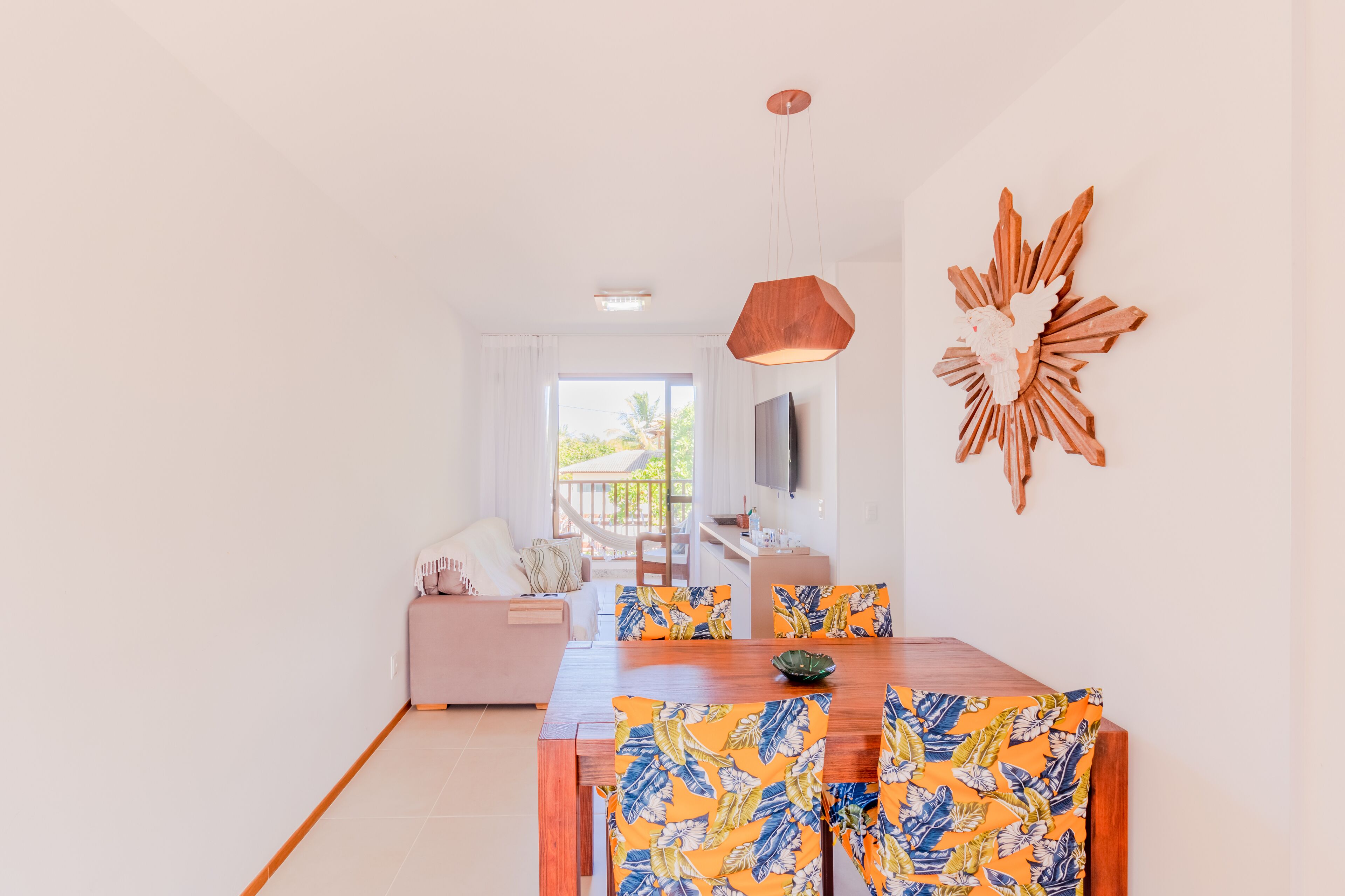 A modern dining area with a wooden table and colorful floral chairs.