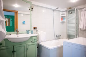 A bathroom with a sink, mirror, shower, and bathtub. - Relaxing, comfortable, and convenient for exploring Naples (Napoli)