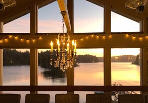 Enjoy breathtaking views of the lake from the comfort of your room, where a chandelier and string lights create a warm ambiance.