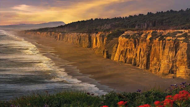 Paesaggio costiero con scogliere e una spiaggia.