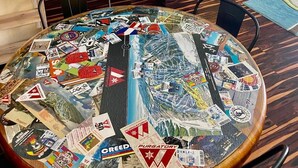 A room with a round table covered in travel brochures, a kitchen area with cabinets and a microwave, and a green wall with a height limit sign. - PROMO 5% WEEKLY AND 10% MONTHLY
Fun 2 bedroon/2 bath condo steps from the slopes (Durango)