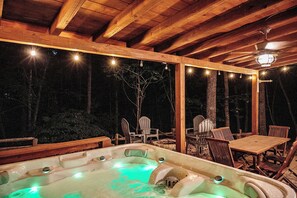 Uma área de hidromassagem com móveis de madeira e luzes de cordão.
