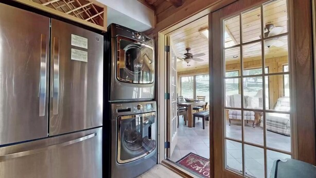 Una cocina con electrodomésticos de acero inoxidable, horno empotrado y un amplio ventanal corredera que da a un patio exterior.