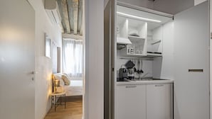 A modern kitchen with white cabinets, a stainless steel sink, and a countertop with a coffee maker. - Ca' dell'Arciere - Superior Apartment in the Heart of Venice (Venezia)