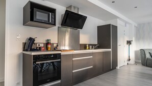Een moderne keuken met roestvrijstalen apparatuur, een magnetron en een inbouwoven.