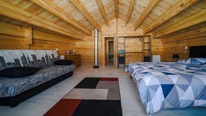 Un dormitorio de cabaña de madera con dos camas, techo de madera y un mural con vista a la ciudad.