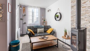 Una sala de estar moderna con un sofá de cuero negro, una mesa de centro de madera y una pared de piedra.
