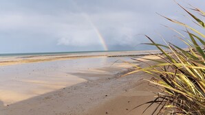 Una playa con un arcoíris en la distancia.