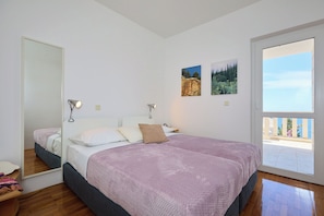 A bedroom with two beds, a large mirror, and a balcony with a view. - Hedera Estate, Hedera A39 (Dubrovnik)