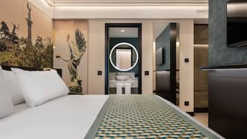 A modern hotel room with a large bed, a bathroom with a mirror, and a TV.