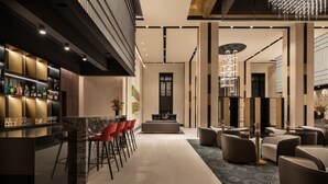 A modern hotel lobby with a bar area, seating, and a central decorative piece. - Eurostars Ambassador (Budapest)