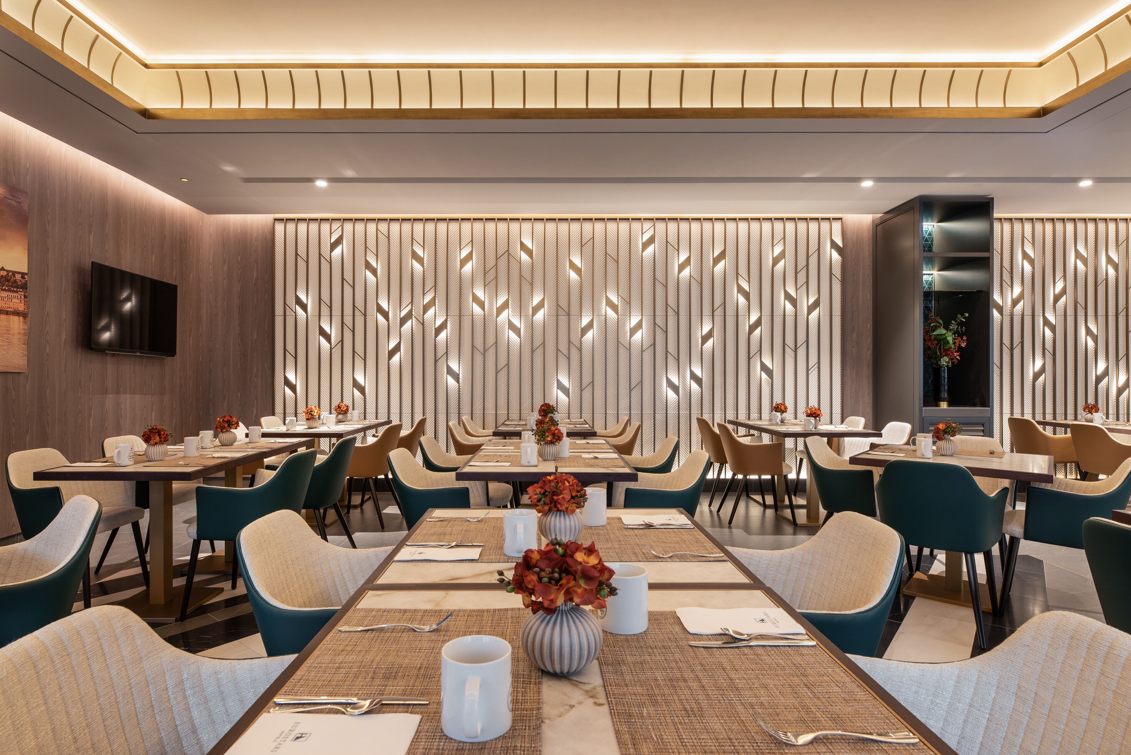 A modern dining area with long tables, chairs, and decorative vases.