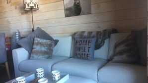 A cozy living room with a grey sofa, decorative pillows, a mounted deer head, and a tray with mugs. - A bit of Alpine heaven with stunning views! (Les Allues)