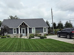 A two-story house with a dark exterior, a front porch, and a well-maintained lawn. - Brand new listing this season
Hickory Lakehouse (Wheatley)