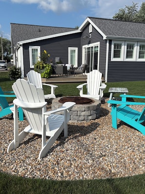 A patio area with Adirondack chairs and a stone fire pit. - Brand new listing this season
Hickory Lakehouse (Wheatley)