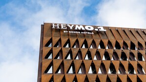 A building with a geometric facade and a sign that reads "HEYMO 1 BY SOKOS HOTELS".