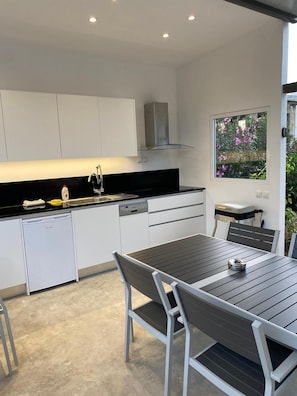 A modern kitchen with white cabinets, a black countertop, and a built-in dishwasher. - Villa Amo With Private Pool (Malevizi)
