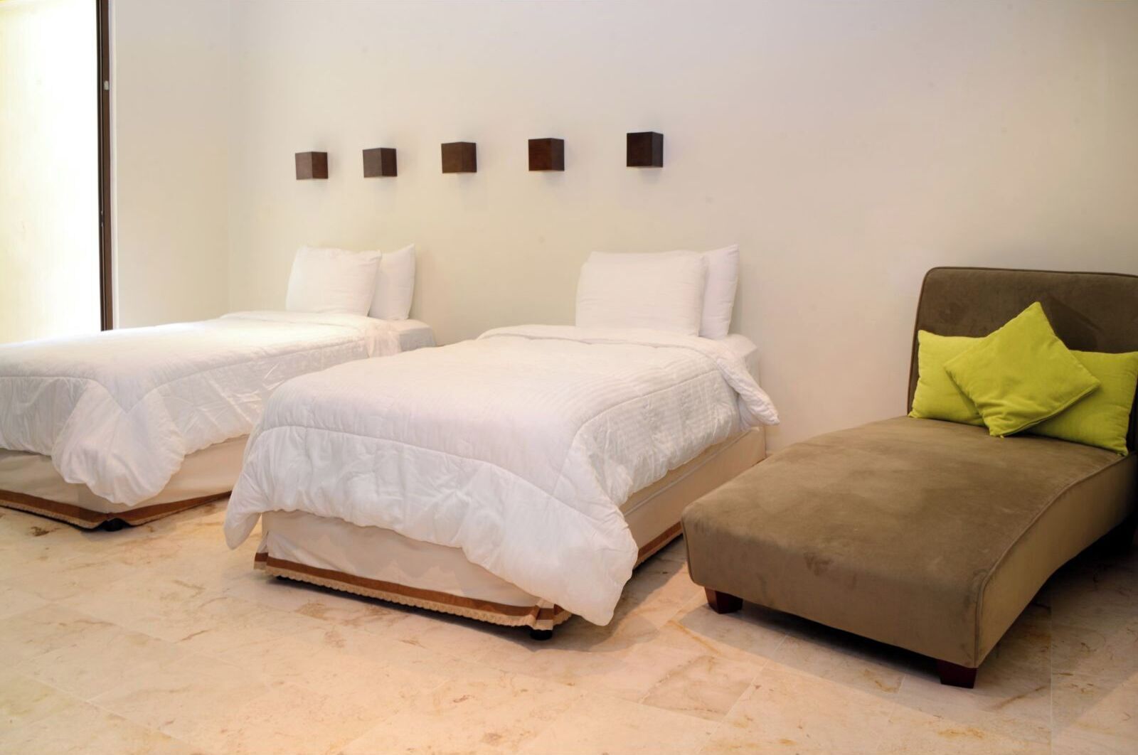 A hotel room with two beds and a sofa.