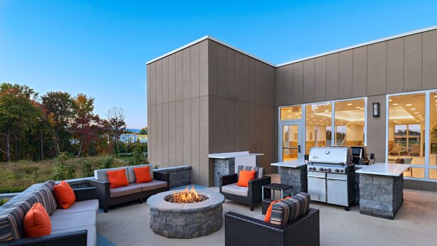 Un patio al aire libre con asientos, un brasero y una zona de barbacoa.