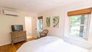 A bedroom with a bed, a dresser, a chair, and a television. - Historical Hotel, Main Street Blowing Rock (Blowing Rock)